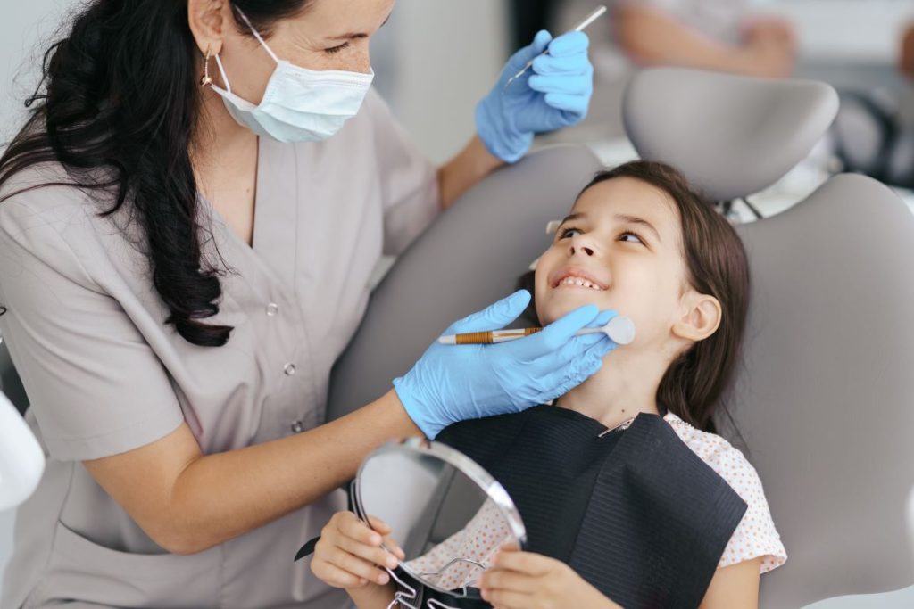 Dentist checking a young girl's teeth for Family Dentistry in Burlington at Burlington Family Dentists - Dental Services