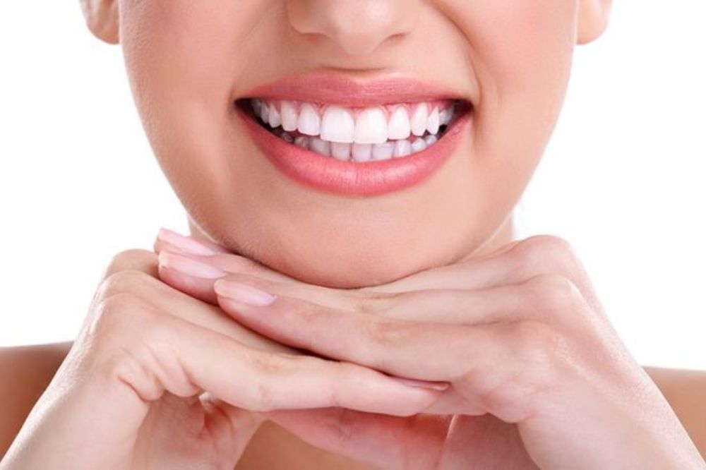 Young woman smiling, showing natural and healthy teeth after cosmetic dentistry.