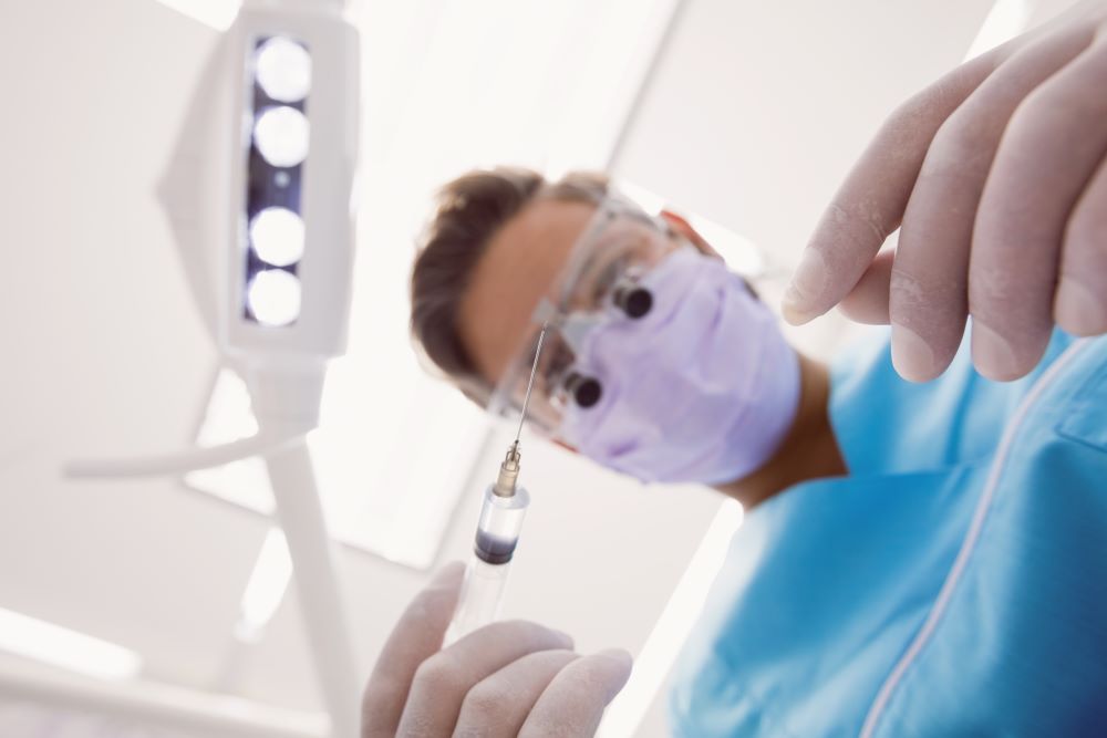 Dentist performing periodontal surgery procedure.