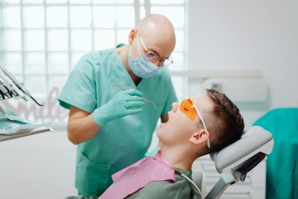 Dentist performing scaling and root planning on a young patient