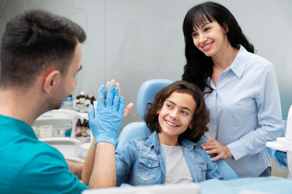 Dentist giving high-five to child for preventive dentistry for families in Burlington