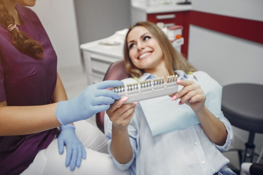 Dentist holding multiple veneer shade samples for patient selection