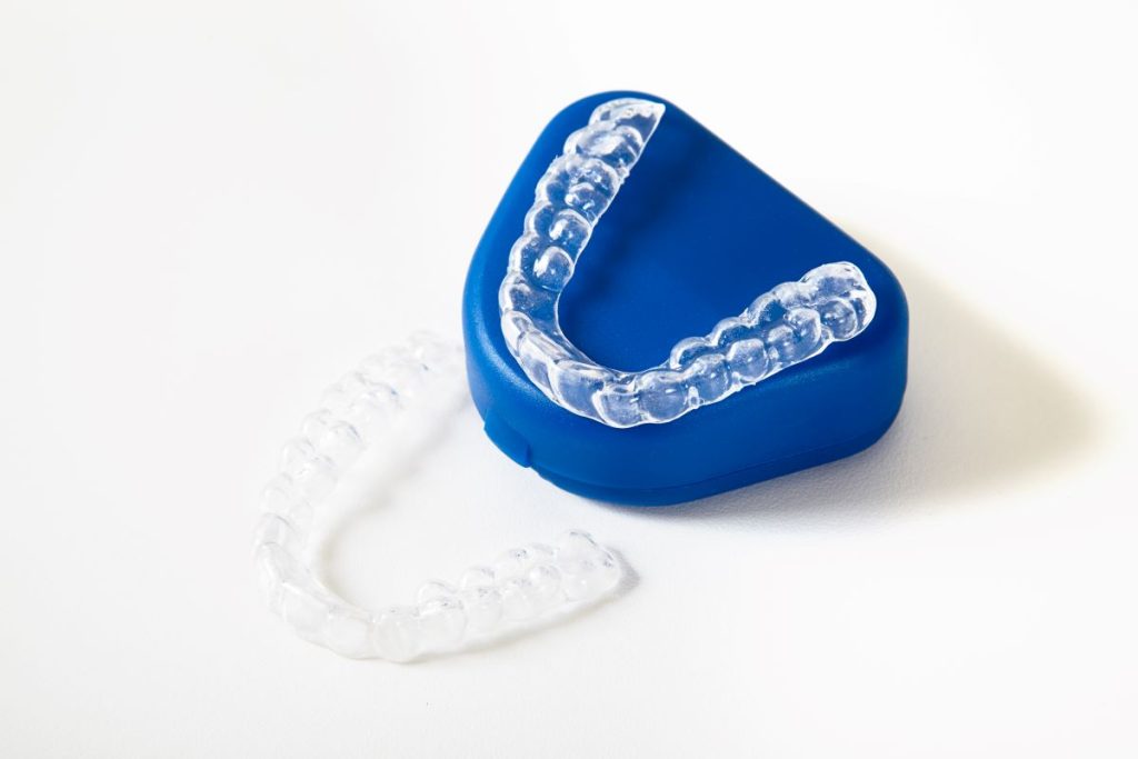 Clear aligners with storage case on a white surface.